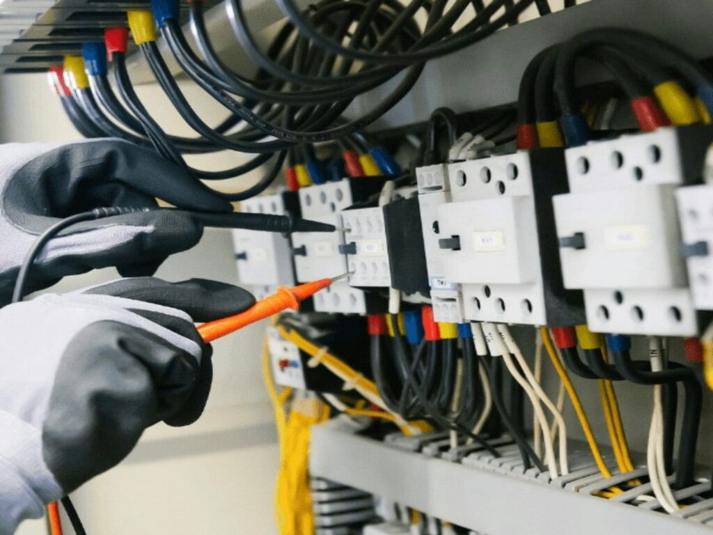Electrician testing electrical equipment and wiring